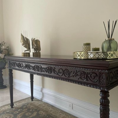 dark wood table against olive wallpaper with gold ornaments